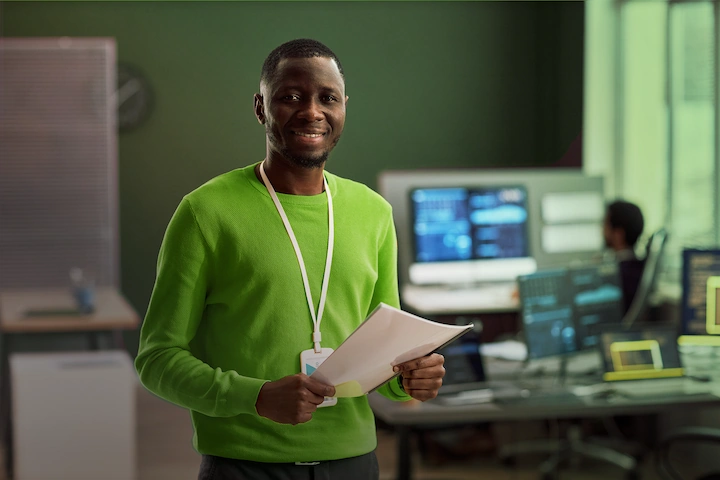 Person standing holding paper and smiling