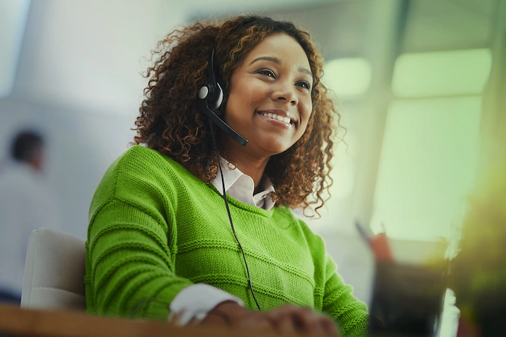 Person talking on a headset at a computer