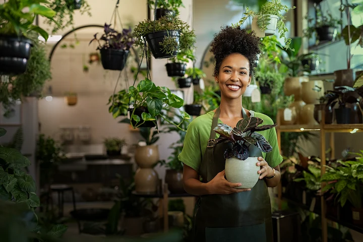 Person standing, holding a plant